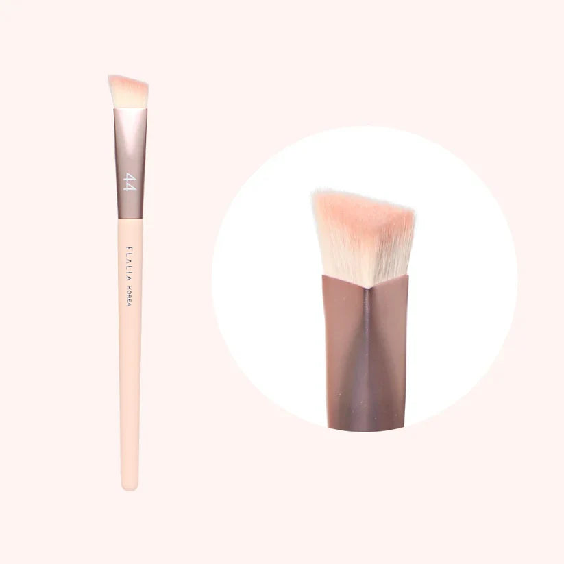 A makeup brush with a flat, angled head and a wooden handle, shown in two different angles to display the design and shape.