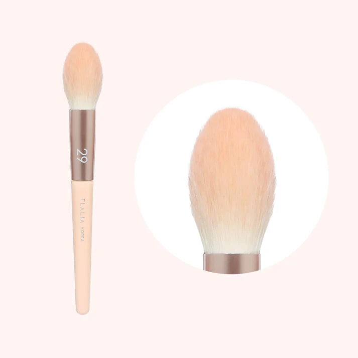 A small powder brush with a light pink handle and beige brush head, displayed on a plain background.